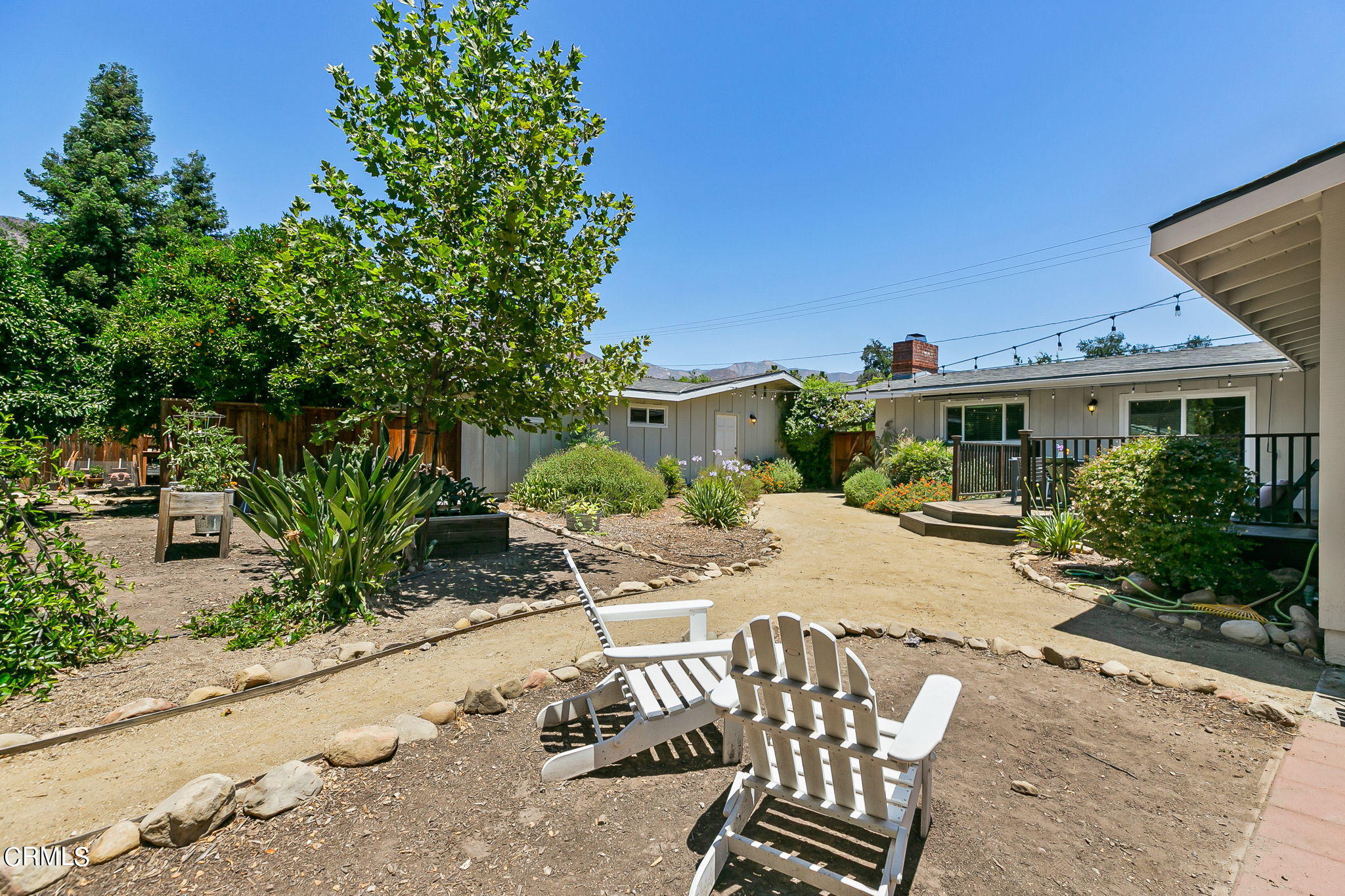 807 Daly Road Ojai, CA 93023 - Photo 42 of 50 a view of a patio with table and chairs and potted plants with wooden fence