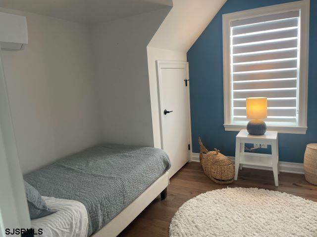 103 North Monroe Avenue, Unit ALSO AVAILABLE STARTING MAY 15 Margate City, NJ 08402 - Photo 28 of 33 a bedroom with a bed and chair