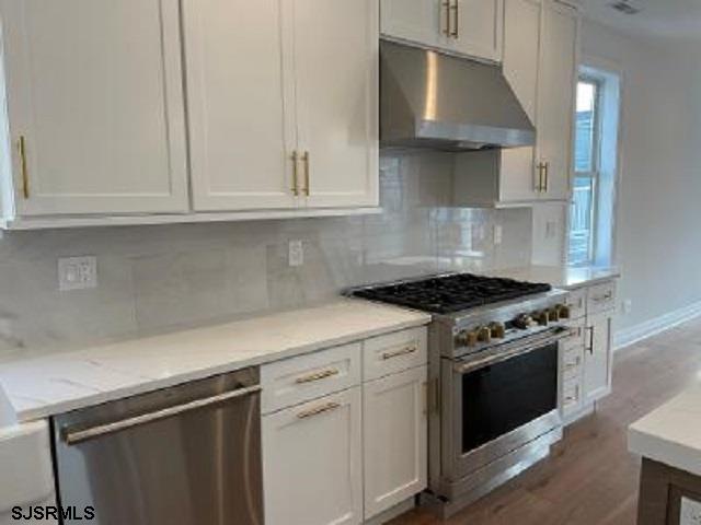 103 North Monroe Avenue, Unit ALSO AVAILABLE STARTING MAY 15 Margate City, NJ 08402 - Photo 4 of 33 a kitchen with white cabinets and a stove top oven