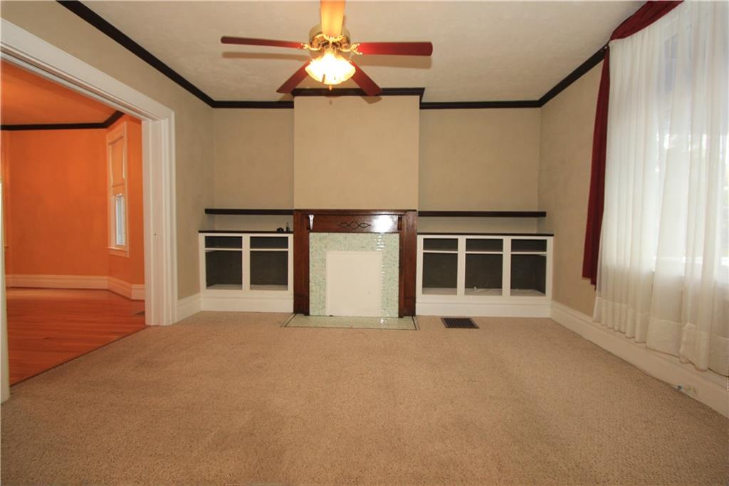 915 Malvern Road Pittsburgh, PA 15202 - Photo 2 of 23 This picture of the living room shows the large window in the front of the room that showers the living room with natural light. The opening to the left leads to the Dining Room. There are oak hardwood floors under the carpet.
