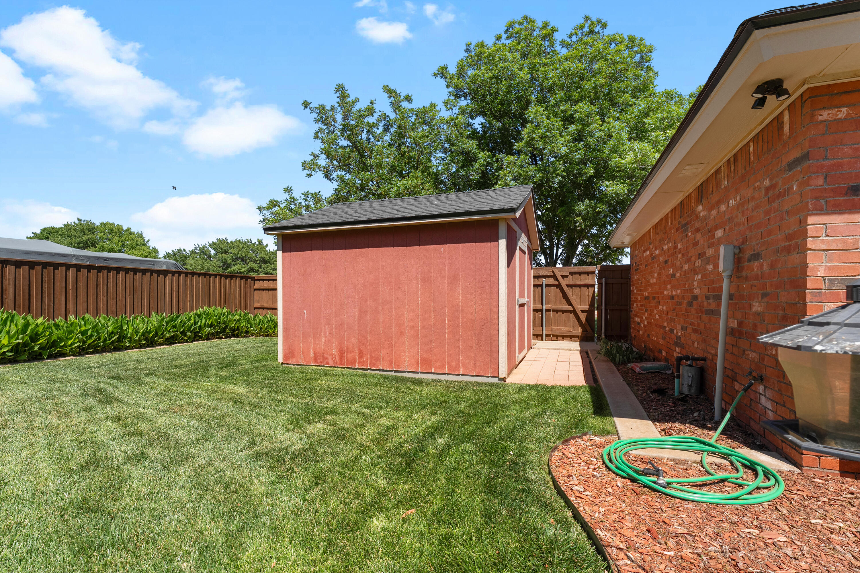 7402 95th Street Lubbock, TX 79424 - Photo 41 of 43 a view of backyard with chair and potted plants