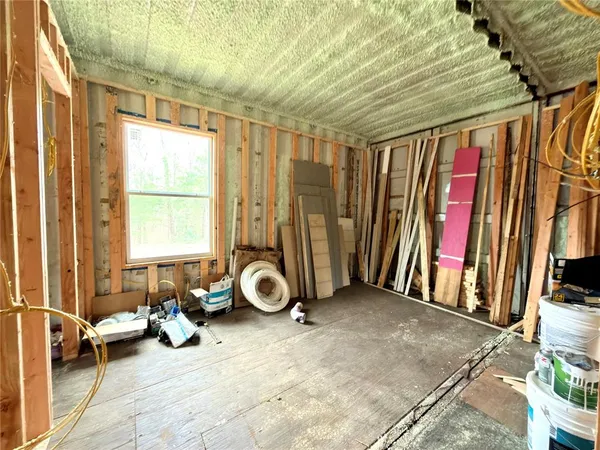 a view of an empty room with wooden floor and windows
