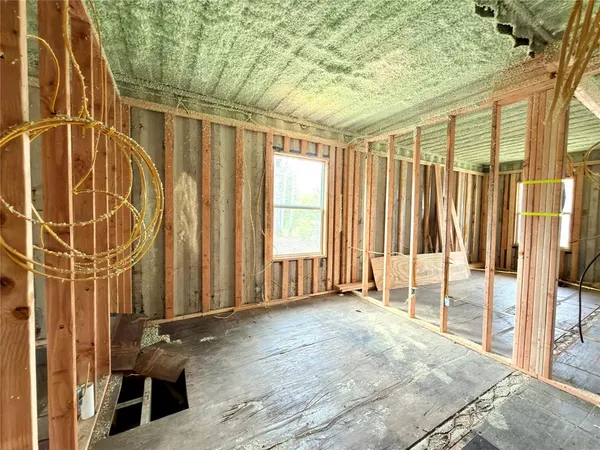a view of an empty room with wooden floor and windows