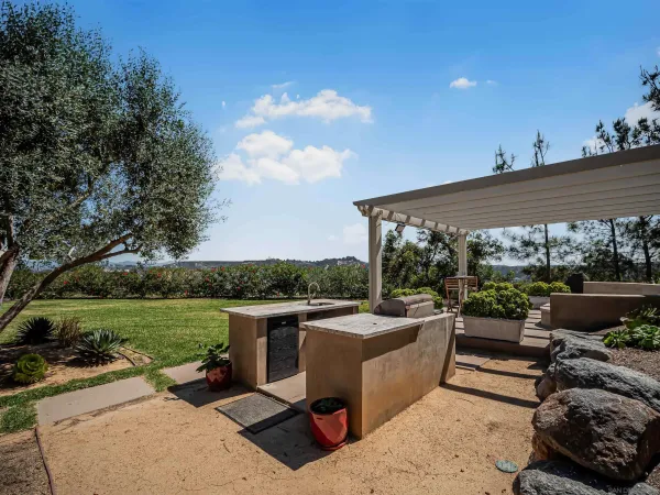 a view of a kitchen with kitchen island a large counter space appliances and a large window