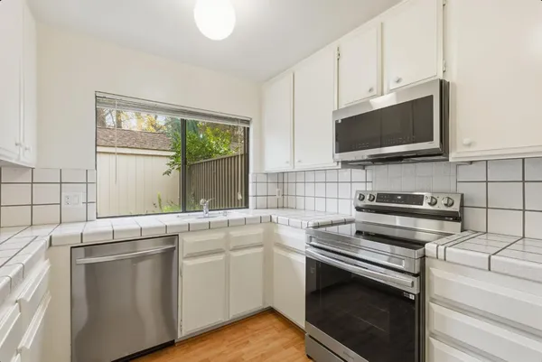 a kitchen with stainless steel appliances a stove microwave and sink