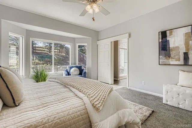 a spacious bedroom with a bed and glass window