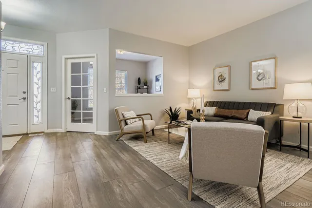 a living room with furniture and a wooden floor