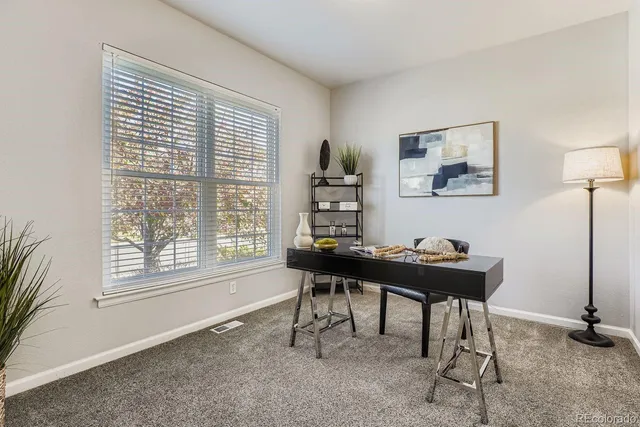 a view of a workspace with furniture and a window