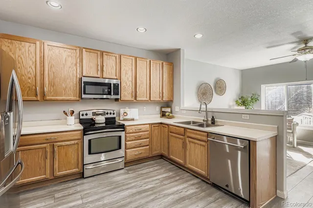 a kitchen with stainless steel appliances granite countertop a stove a sink and a microwave