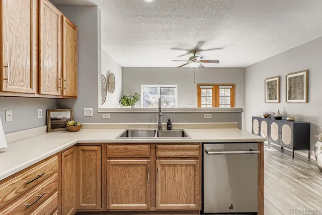 a kitchen with stainless steel appliances granite countertop a sink and dishwasher with wooden floor
