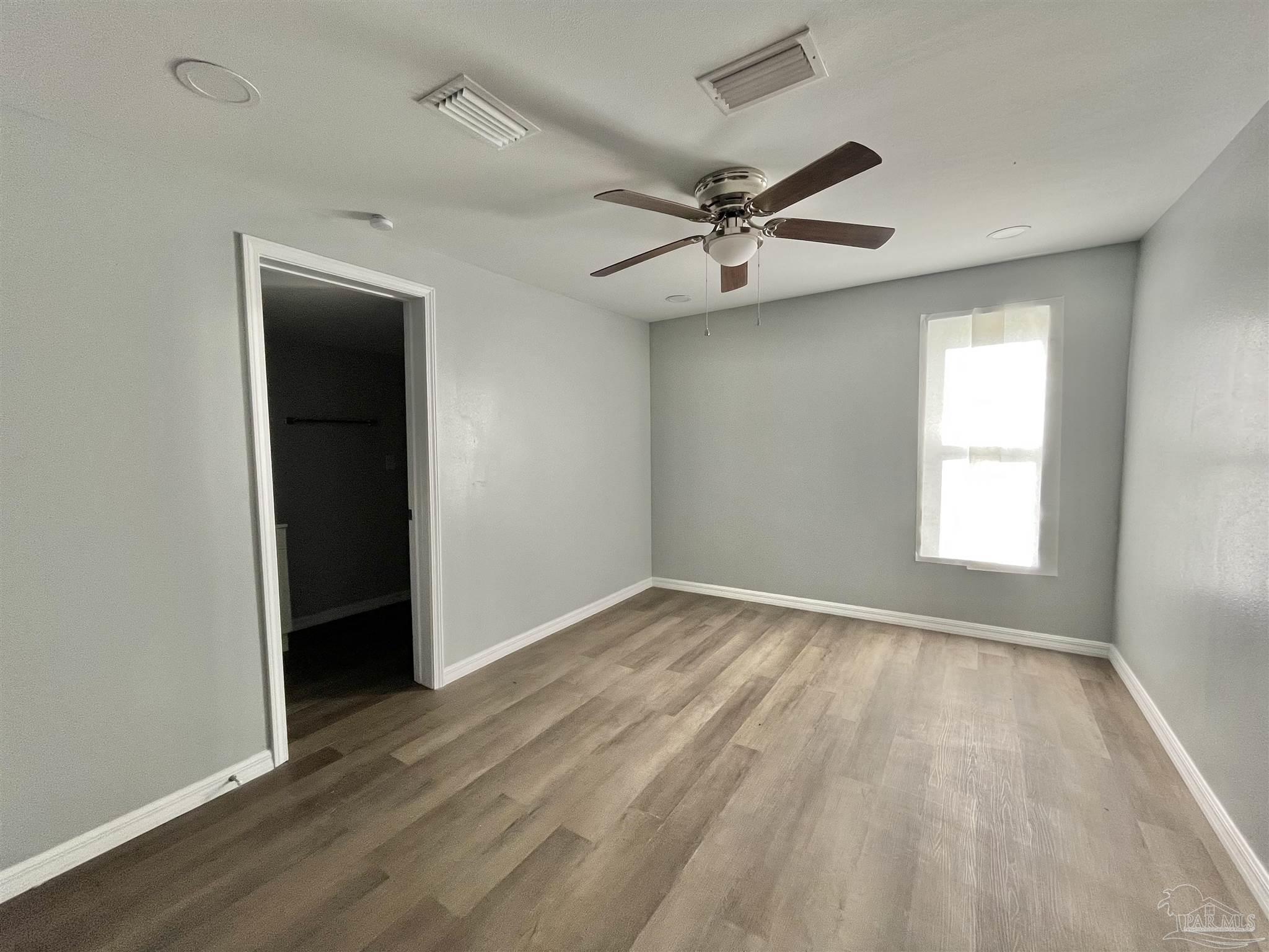 102 W Avenue Atmore, AL 36502 - Photo 11 of 25 wooden floor in an empty room with a window