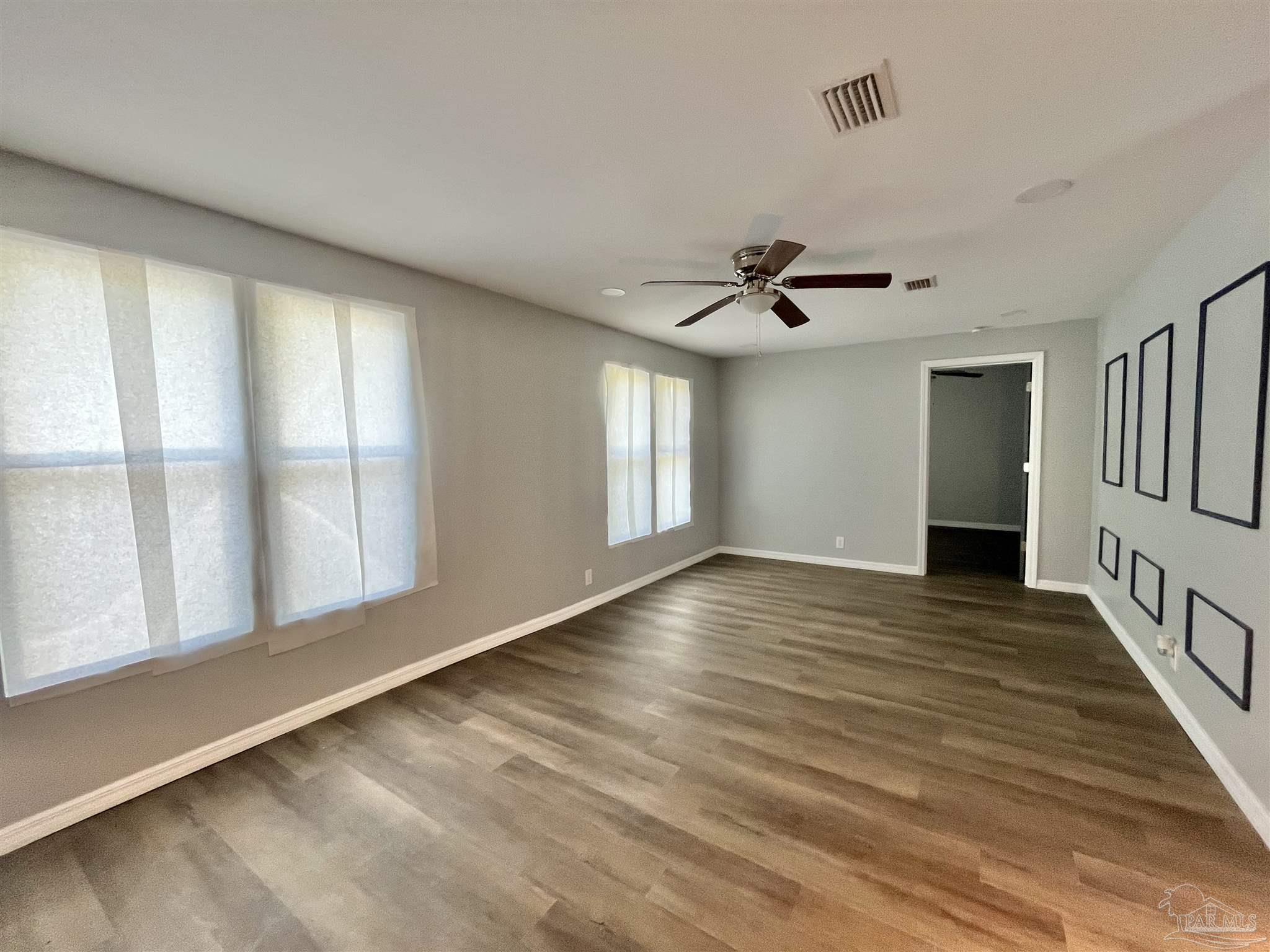 102 W Avenue Atmore, AL 36502 - Photo 12 of 25 a view of an empty room with a window and wooden floor