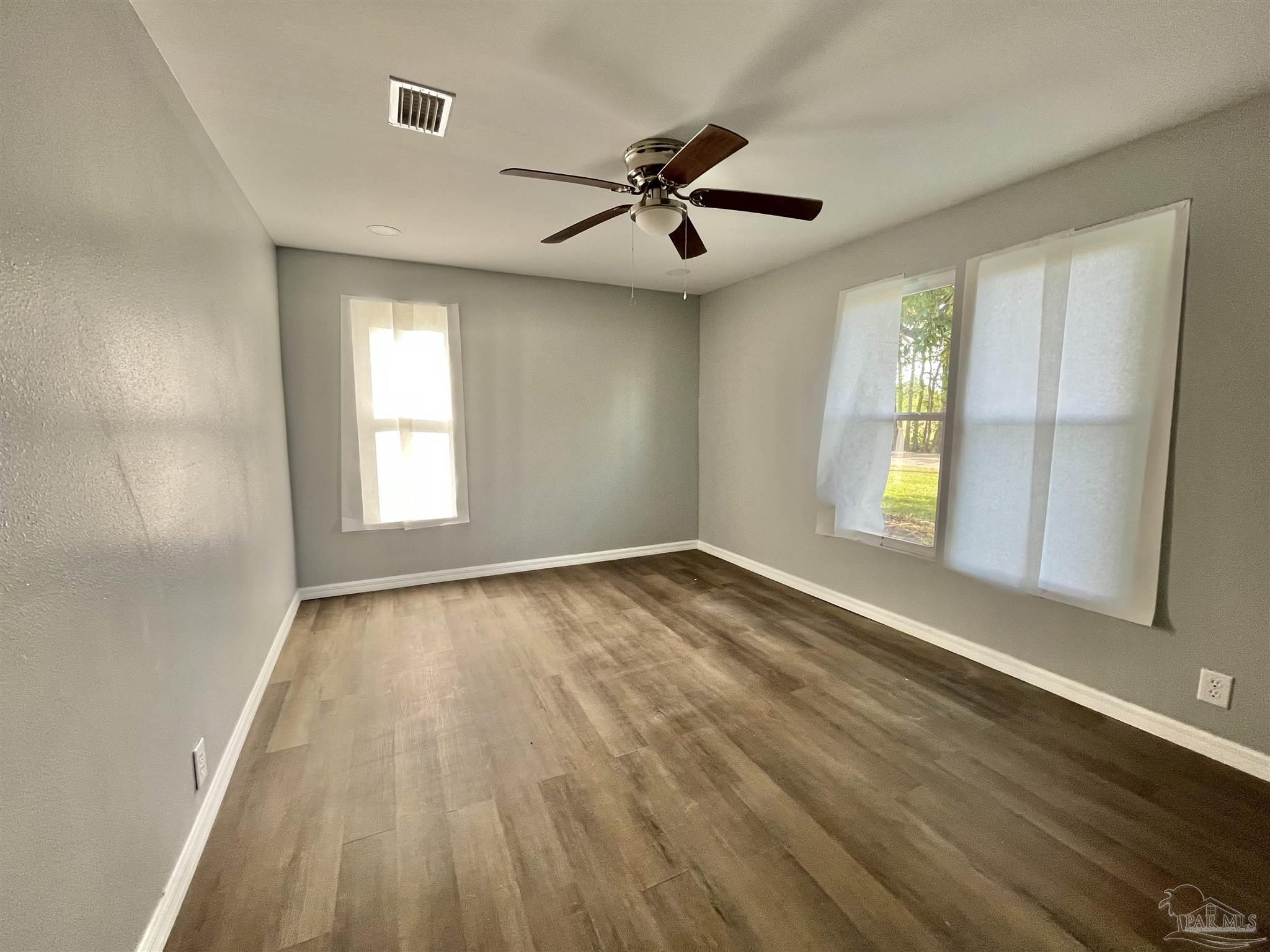 102 W Avenue Atmore, AL 36502 - Photo 13 of 25 wooden floor in an empty room with a window