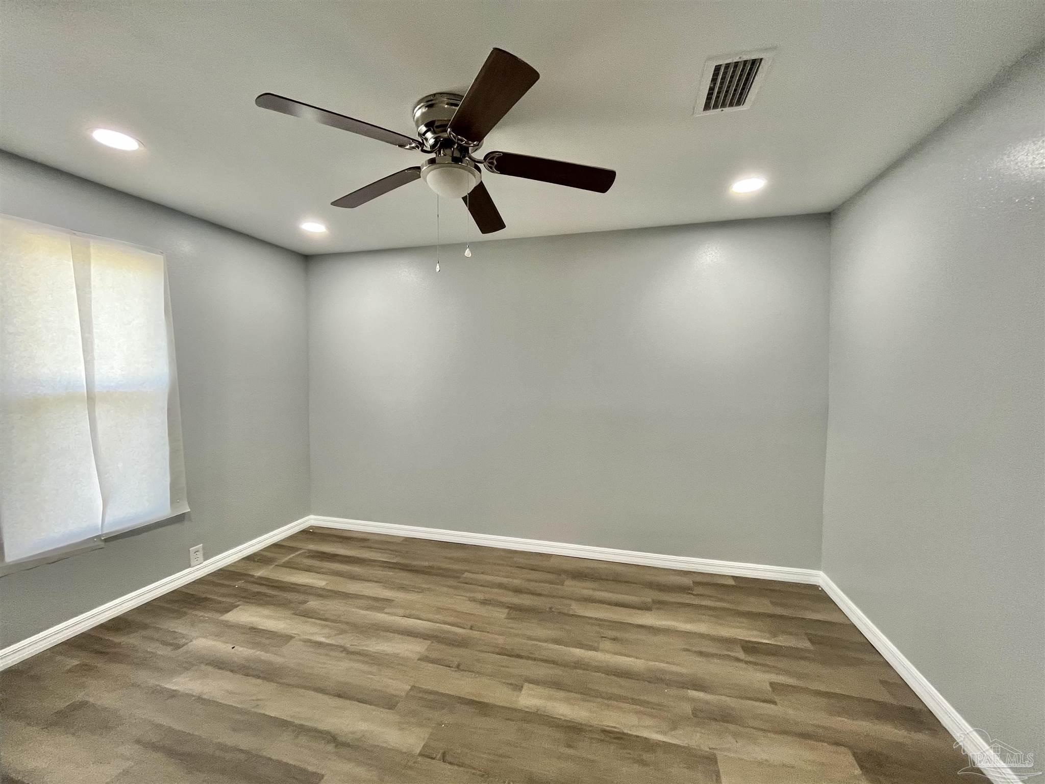 102 W Avenue Atmore, AL 36502 - Photo 14 of 25 an empty room with wooden floor and windows