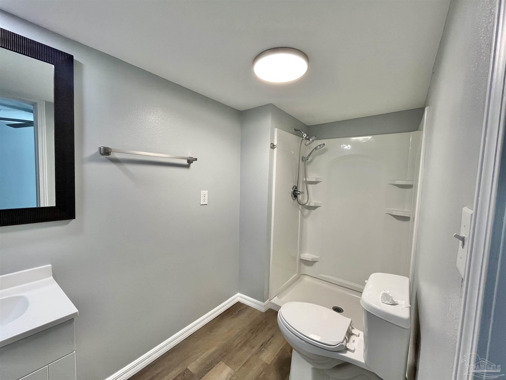 102 W Avenue Atmore, AL 36502 - Photo 16 of 25 a bathroom with a granite countertop toilet a sink and shower
