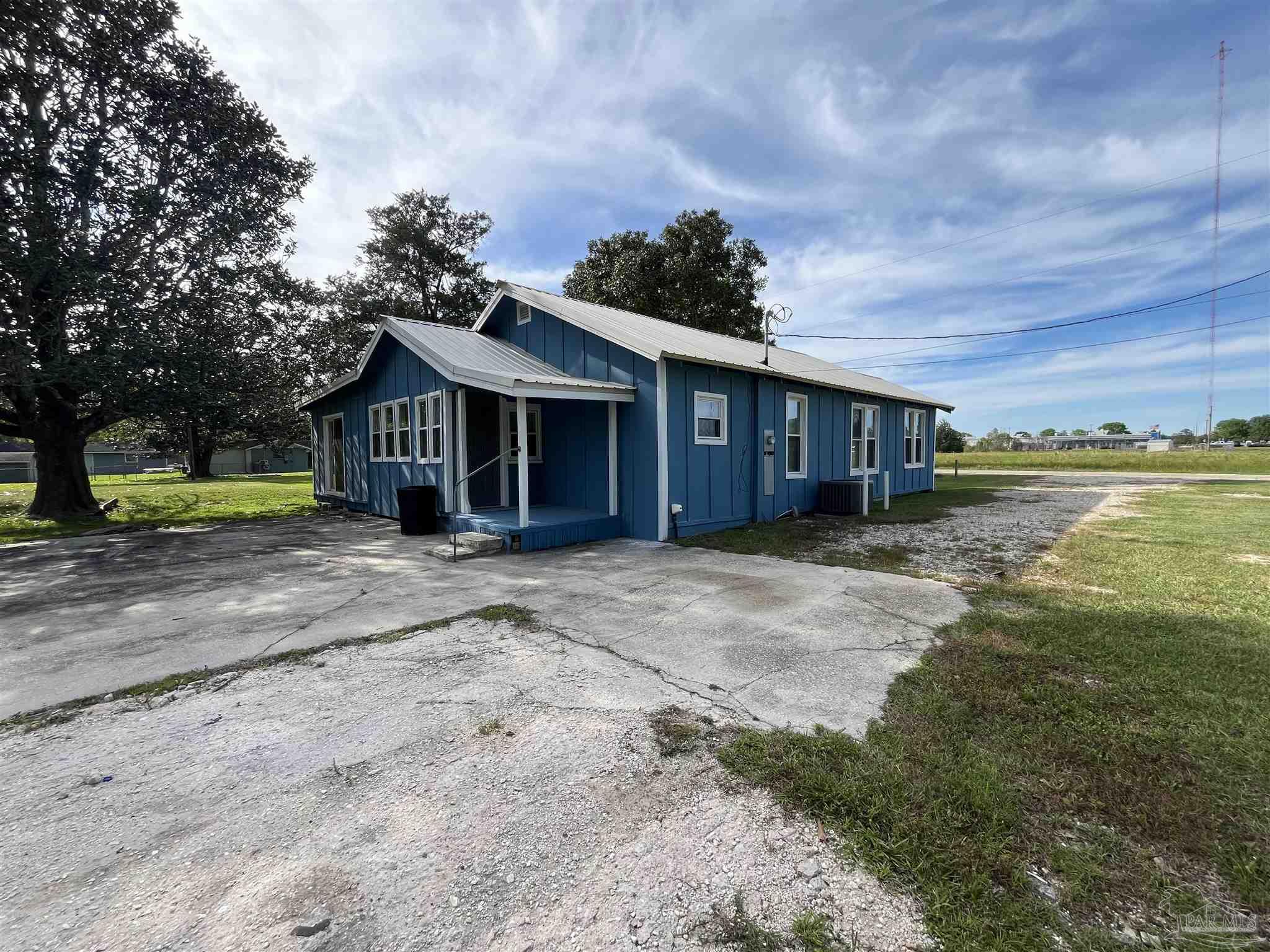 102 W Avenue Atmore, AL 36502 - Photo 23 of 25 a view of a house with a yard and a large tree