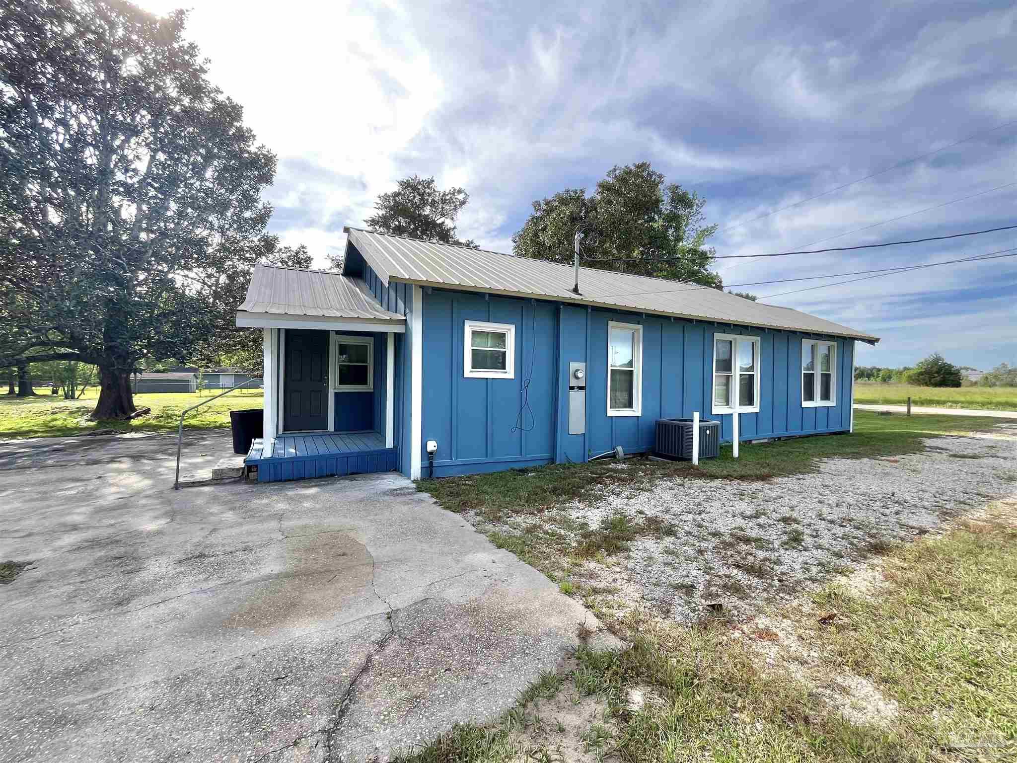 102 W Avenue Atmore, AL 36502 - Photo 5 of 25 a view of a house with a yard and large tree