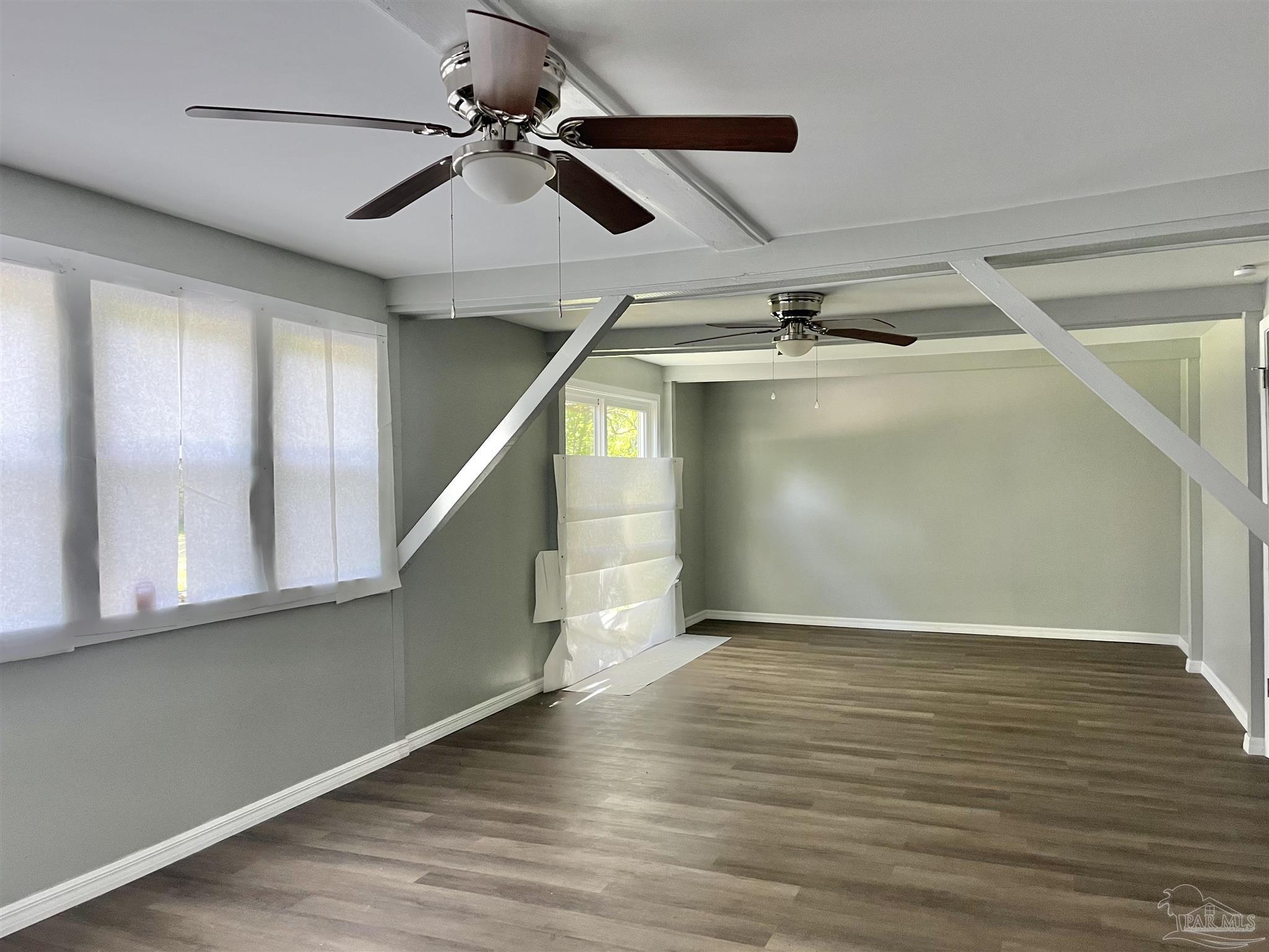 102 W Avenue Atmore, AL 36502 - Photo 6 of 25 a view of an empty room with wooden floor and a ceiling fan