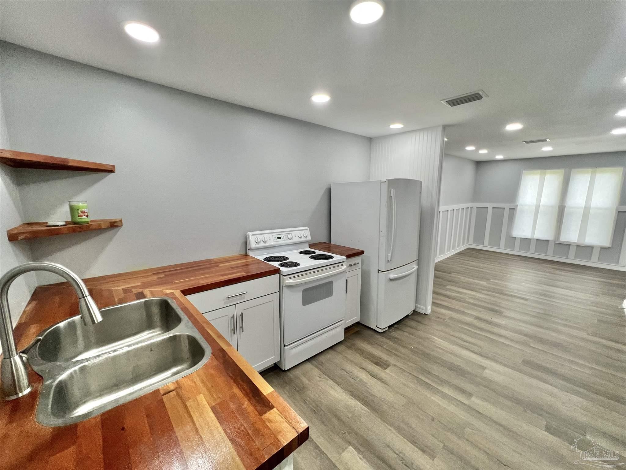 102 W Avenue Atmore, AL 36502 - Photo 7 of 25 a kitchen with a stove and a refrigerator