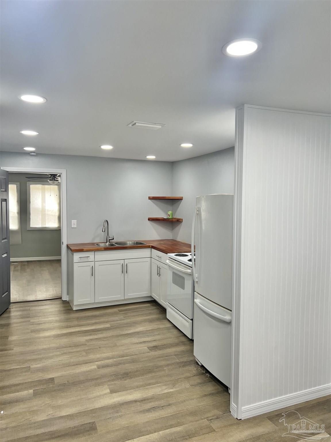 102 W Avenue Atmore, AL 36502 - Photo 10 of 25 a kitchen with a white stove refrigerator and cabinets