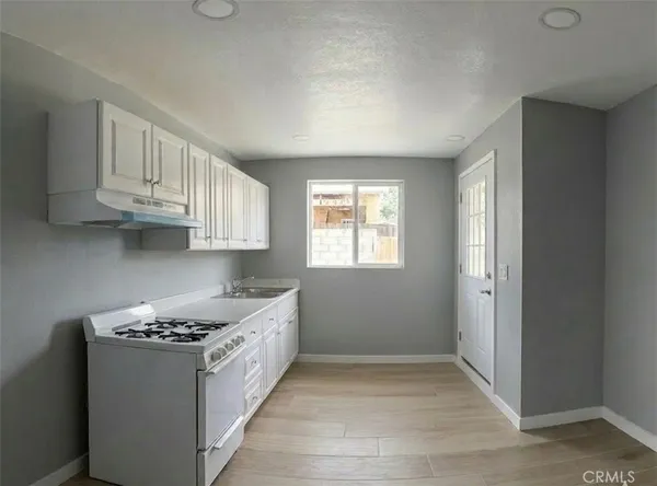 a kitchen with stainless steel appliances granite countertop a sink stove and cabinets