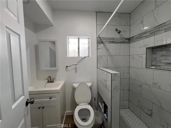 a bathroom with a toilet a sink and mirror
