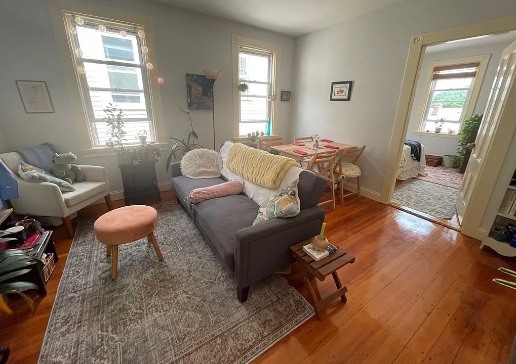 a living room with furniture a wooden floor and a large window