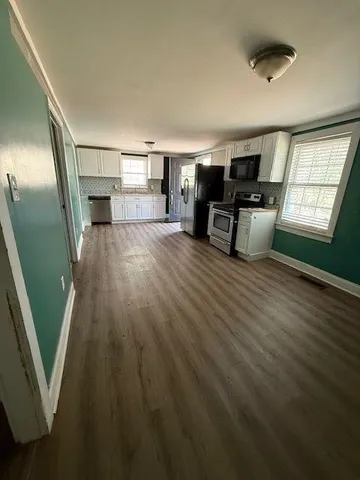 a view of a livingroom with furniture wooden floor and windows