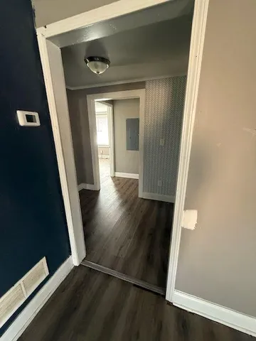 a view of a hallway with wooden floor