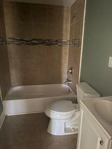 a white toilet sitting next to a bath tub