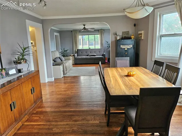a dining room with wooden floor and stainless steel appliances