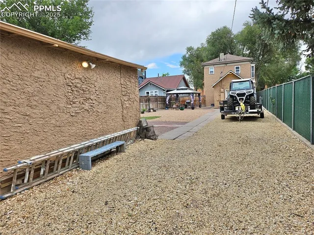 a view of a roof deck with wooden fence and a couple of chairs