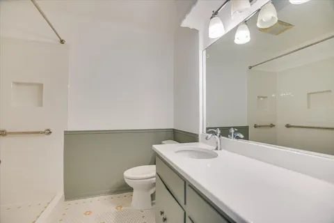 a bathroom with a sink a toilet and a mirror