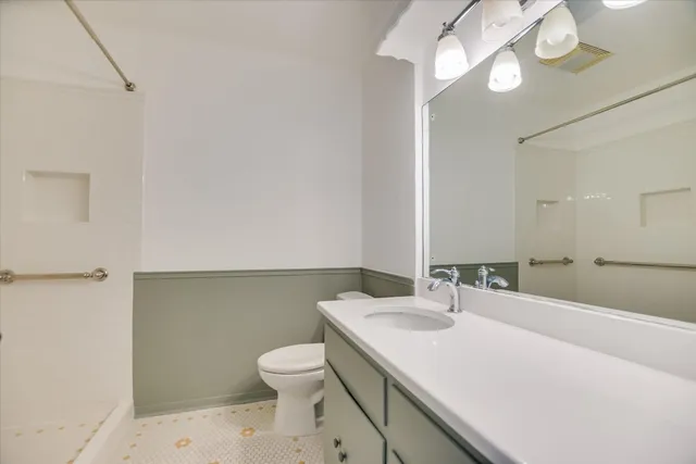 a bathroom with a sink a toilet and a mirror