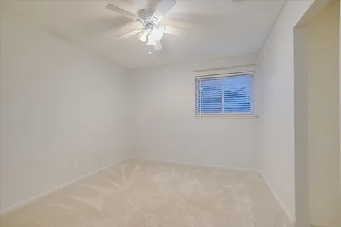 an empty room with a chandelier fan