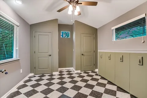 a view of a livingroom with a chandelier fan and windows