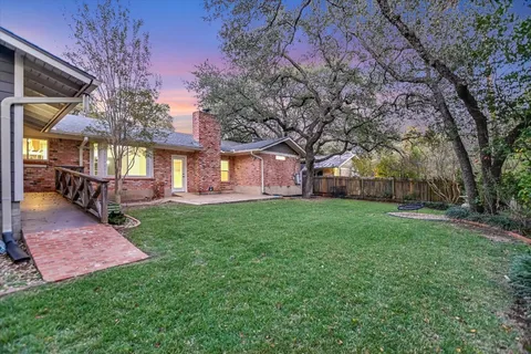 a view of a house with backyard and a tree