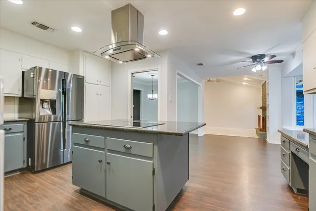 a kitchen with stainless steel appliances granite countertop a refrigerator a sink and a stove