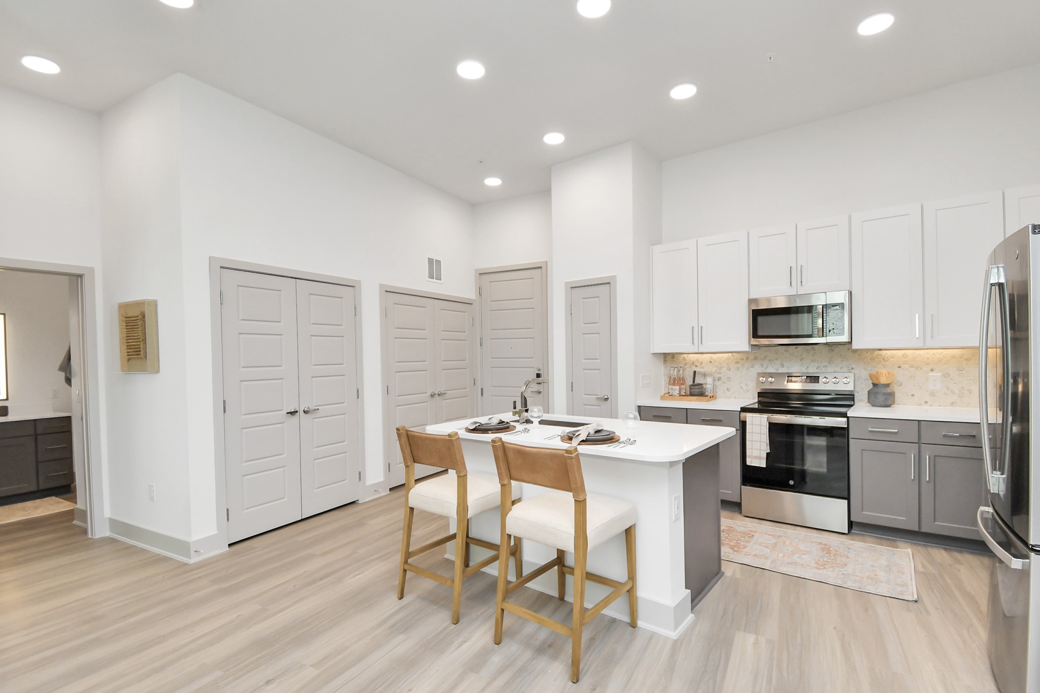 1617 Enid Street, Unit 177 Houston, TX 77009 - Photo 2 of 50 a kitchen with stainless steel appliances kitchen island granite countertop a stove top oven a sink dishwasher and a refrigerator with wooden floor