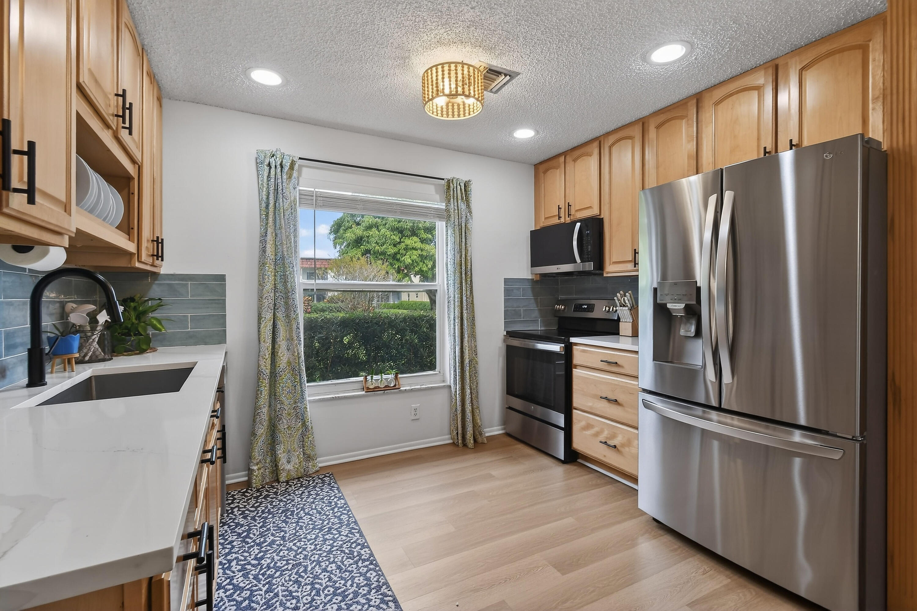 717 Highway 1, Unit 912 Jupiter, FL 33477 - Photo 12 of 45 a kitchen with a refrigerator microwave and stove top oven