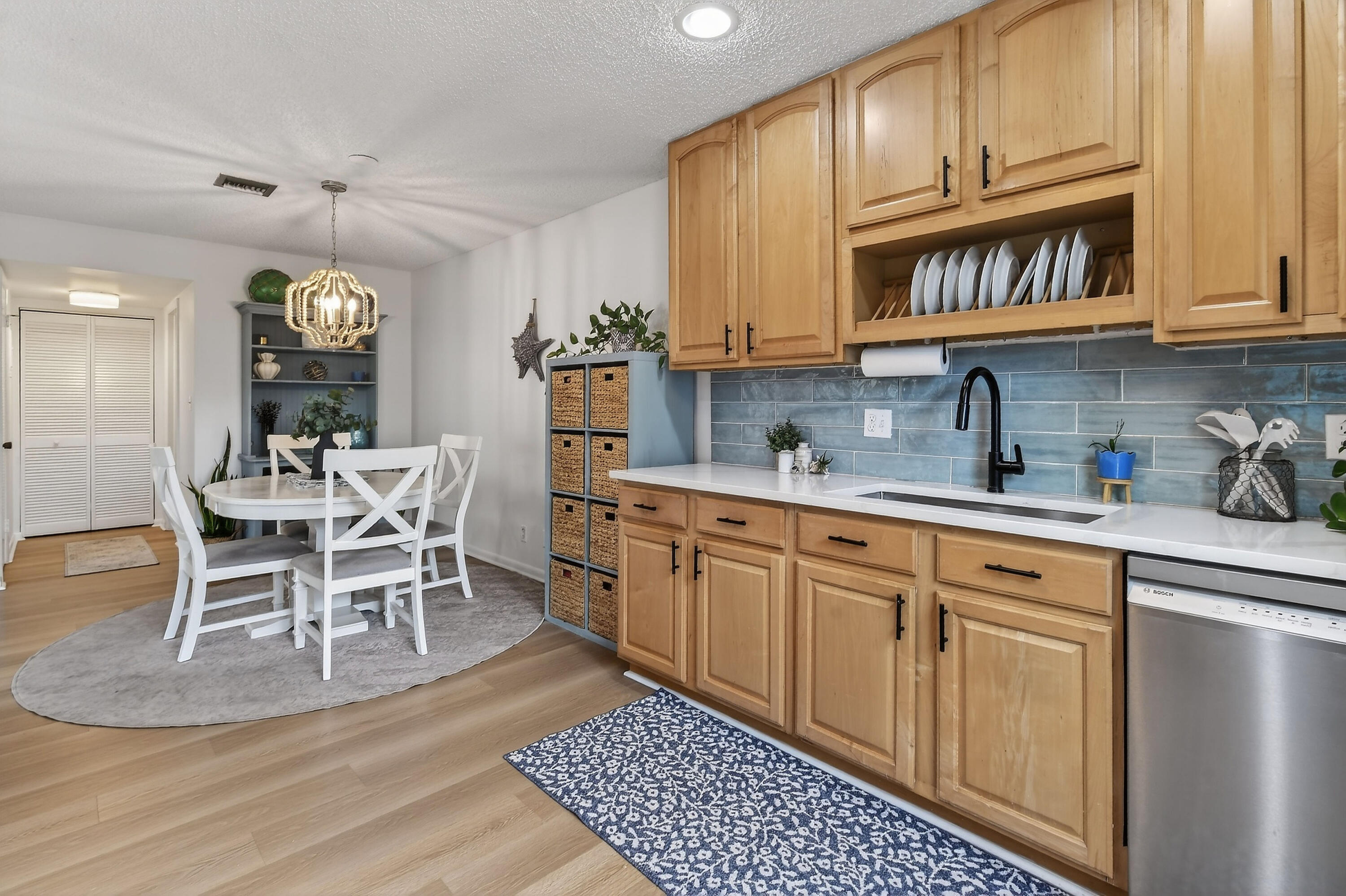 717 Highway 1, Unit 912 Jupiter, FL 33477 - Photo 14 of 45 a kitchen with stainless steel appliances granite countertop a stove a sink dishwasher and white cabinets with wooden floor