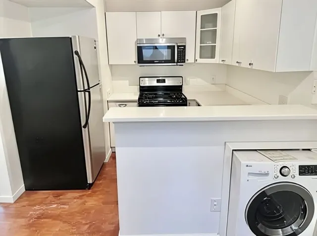 a kitchen with stainless steel appliances granite countertop a refrigerator and a stove