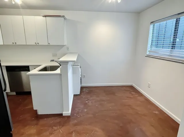 a view of a kitchen with white cabinets and sink