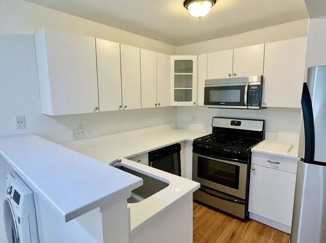 a kitchen with cabinets appliances and a counter space