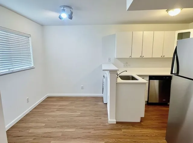 a utility room with wooden floor washer and dryer