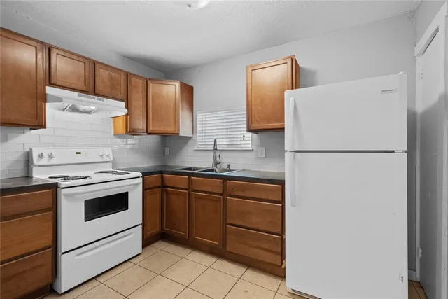 a kitchen with a refrigerator sink stove and cabinets