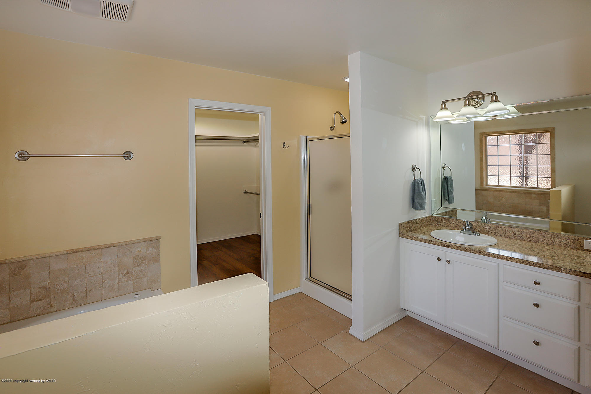 7003 Nick Street Amarillo, TX 79119 - Photo 13 of 34 a spacious bathroom with a granite countertop sink a mirror and a shower