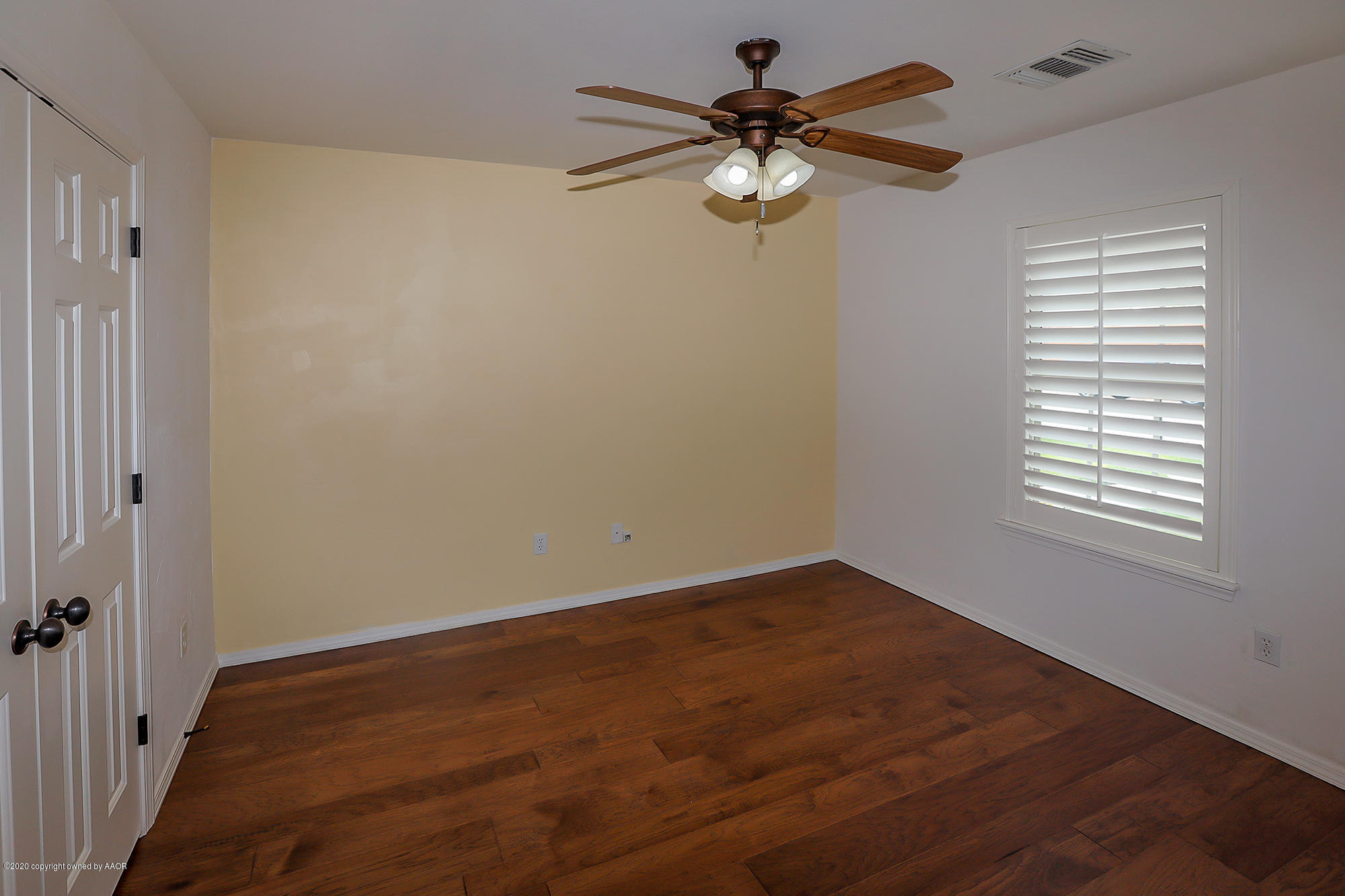7003 Nick Street Amarillo, TX 79119 - Photo 17 of 34 an empty room with wooden floor chandelier fan and windows