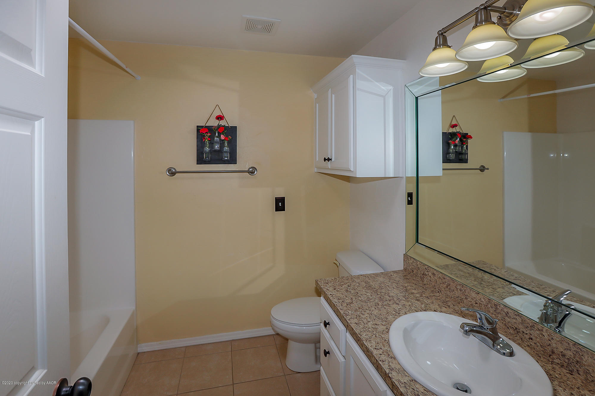 7003 Nick Street Amarillo, TX 79119 - Photo 19 of 34 a bathroom with a granite countertop toilet sink and mirror