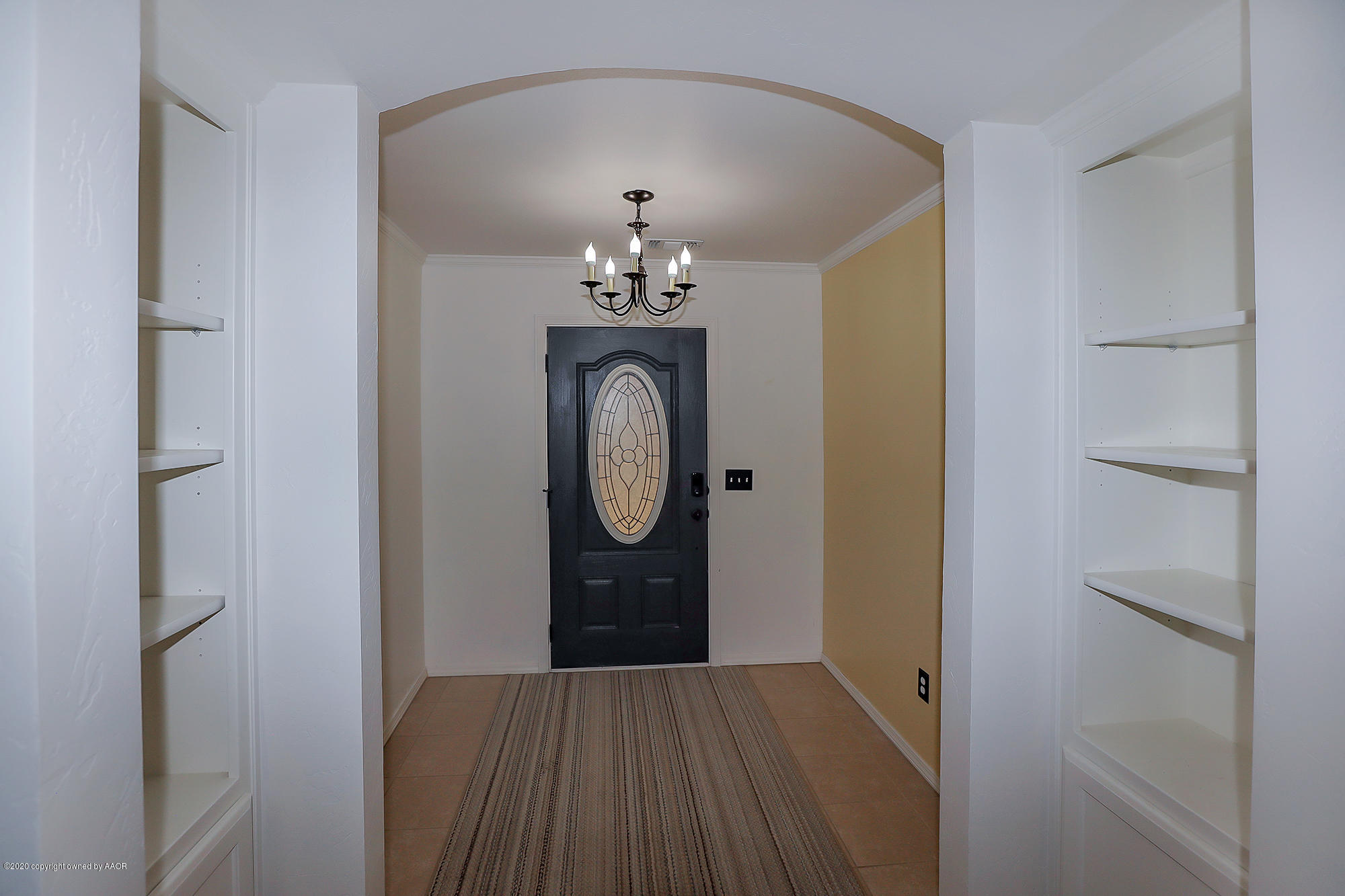 7003 Nick Street Amarillo, TX 79119 - Photo 4 of 34 a view of a hallway with wooden floor and chandelier